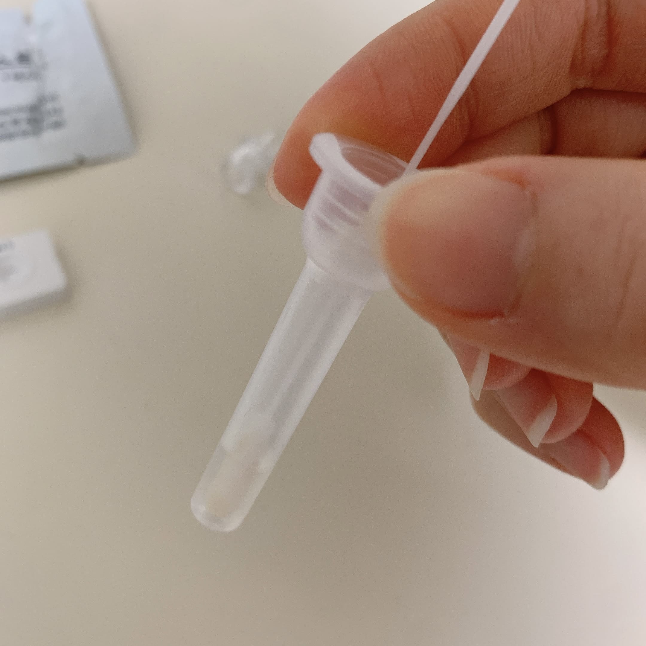 코로나19 자가진단 키트 콧속에서 꺼낸 멸균 면봉 용액통에 넣기