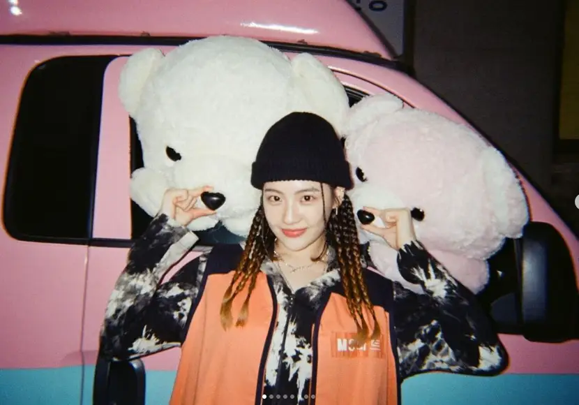 브레이드 머리에 비니를 쓰고 큰 곰돌이의 코를 만지고 있는 조아람.