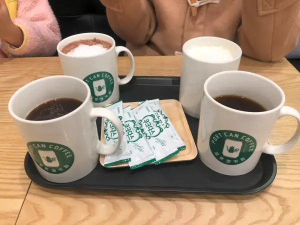 커피 테이블 위에 올려진 음료 네 잔과 쿠키