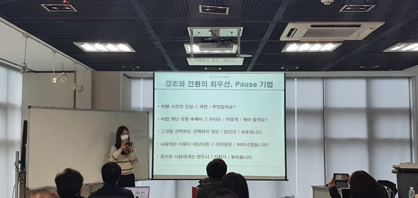 스타트런 지효선 대표가 스피치엥서 강조에 대하여 설명하기 위해 흰색의 보드앞에 서서 강의를 하고 있는 사진