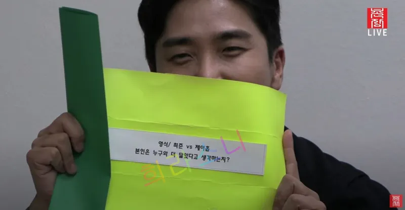 검은색 셔츠를 입은 23기 영식이 형광 녹색 종이를 들어 올리며 웃고 있다. 종이에는 '영식/최준 vs 정이준 본인은 누구와 더 닮았다고 생각하는지?'라는 문구가 적혀 있다. 화면 오른쪽 상단에는 '곤솔 LIVE' 로고가 보인다. 자막은 '희라소니'라고 적혀 있다.