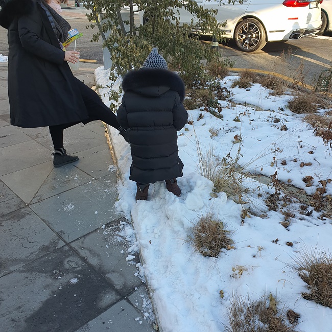 아이가 엄마와 함께 눈놀이를 하고 있다
