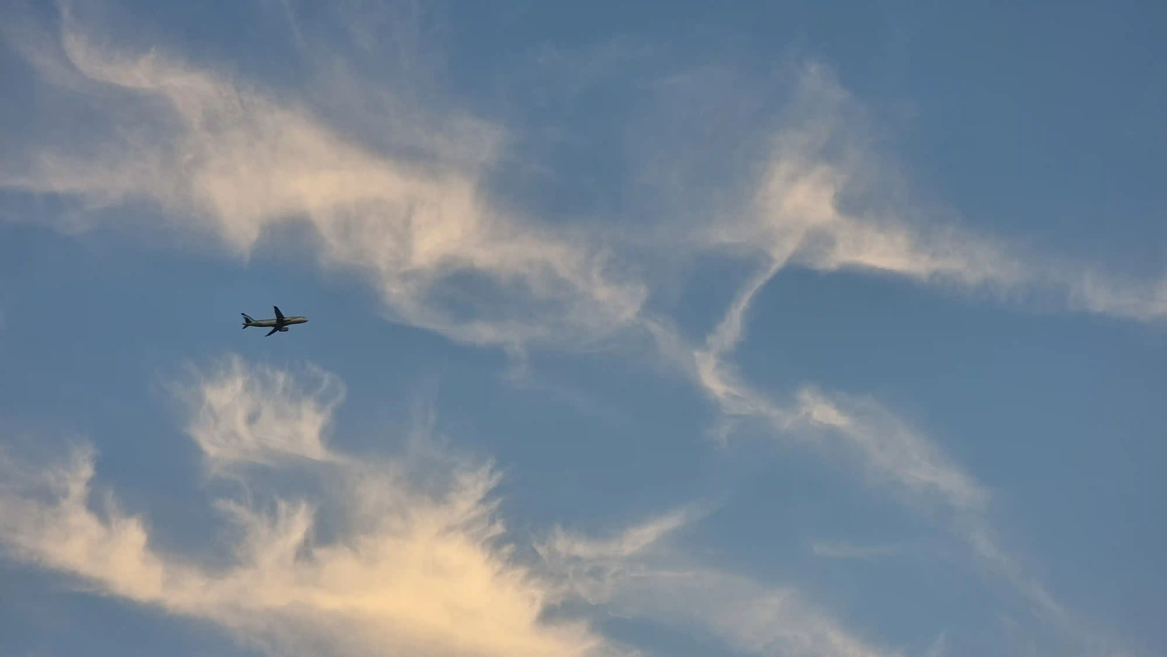 구름 위로 날아가는 비행기 모습