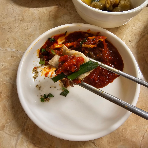 수육을 소스에 찍은 사진