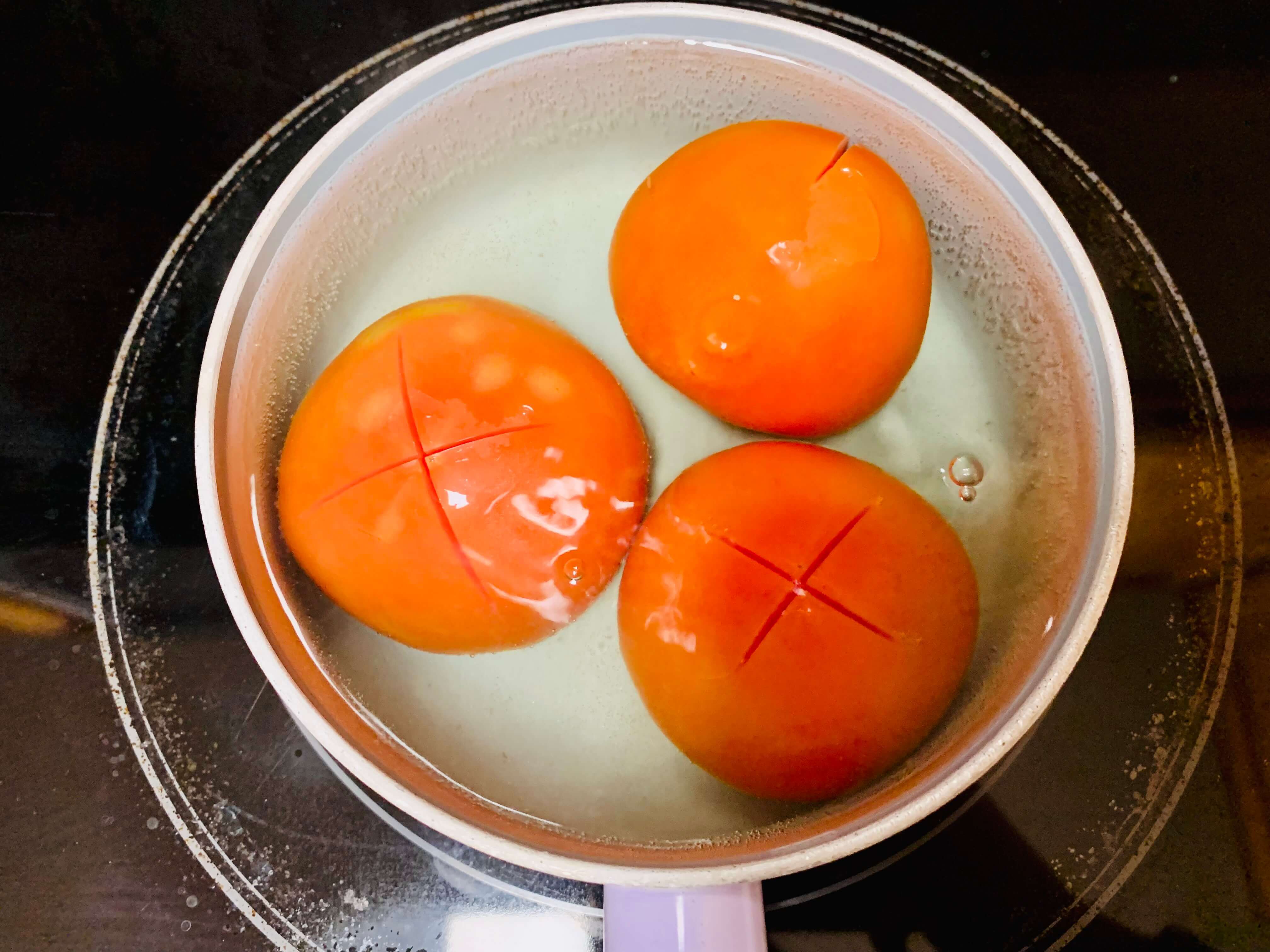 끓는-냄비-안에-빨간-토마토-3개가-담긴-모습