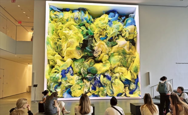 25일 미국 뉴욕 현대미술관(MoMA&#44; 모마)을 찾은 관람객들이 레픽 아나돌의 &#39;비감독(Unsupervised)&#39;(2022)을 감상하고 있다. 실시간으로 색채와 모양이 바뀌는 이 작품은 인공지능(AI)이 모마 소장품 데이터를 수집해 만들었다.