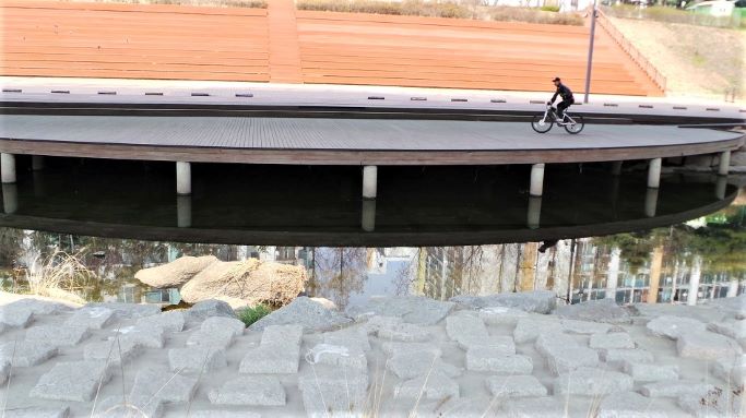 홍제천 입구 반원형 수변무대&#44; 누군가 자전거 타고 지나가고 있음&#44; 물에 비친 수변무대&#44;