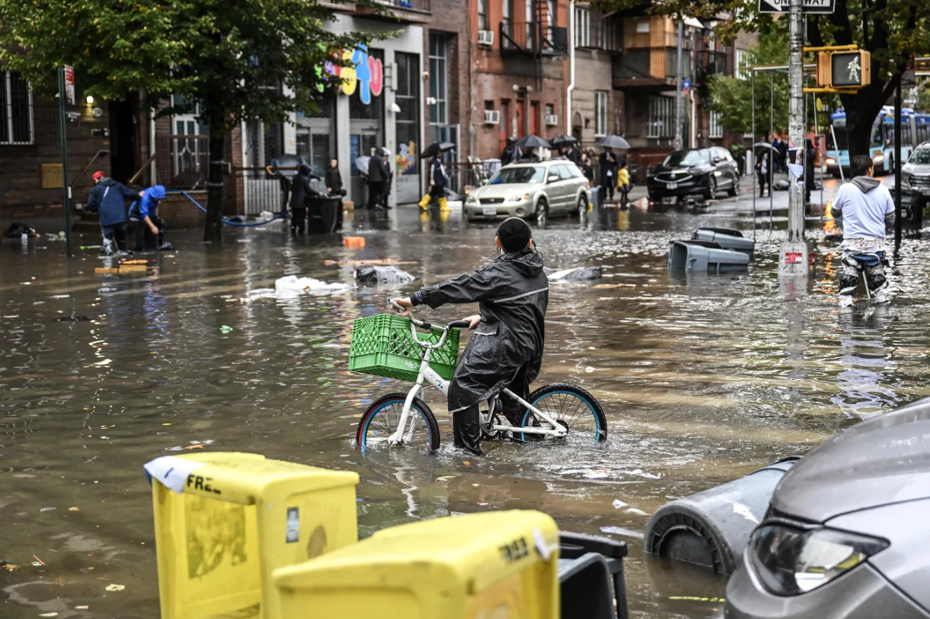 뉴욕시의-침수된-도로에서-자전거를-타는-사람