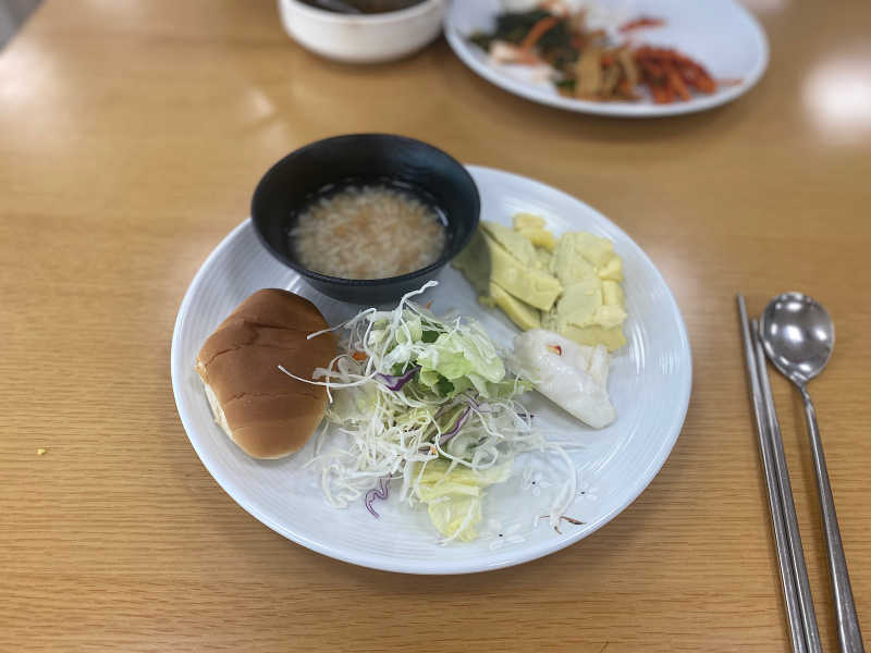 접시위에 야채와 계란찜&#44; 빵과 누룽지가 올려져 있다