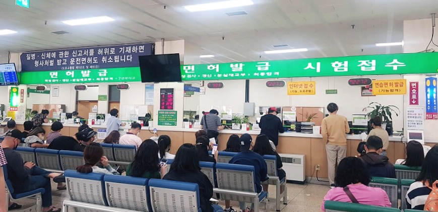 의자에-앉아있는-사람들의-뒷모습과-행정-업무-창구-모습을-찍은-사진