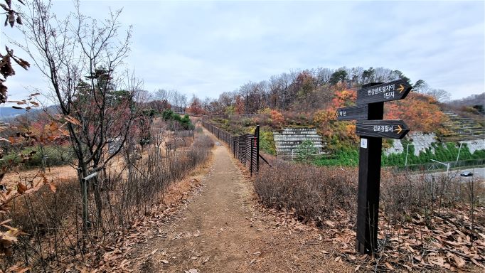 건너 온 생태터널 위&#44; 우측엔 이정표&#44; 김포경찰서 가는 방향&#44; 왼쪽엔 돌무더기&#44;