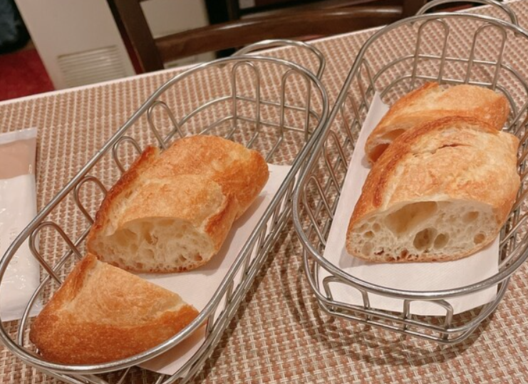 테이블 위의 2개의 조그만한 트레이에 빵이 각각 3개씩 담겨져 있다.