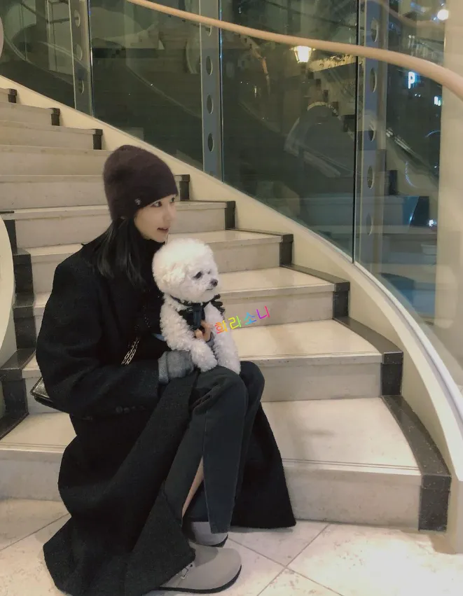 옥순 인스타 사진. 검은색 비니와 검은 코트를 입고 자신의 반려견 슈와 함께 계단에서 사진을 찍은 옥순.