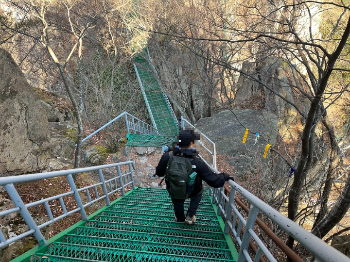 경사진-녹색-계단을-내려가는-사람-한-명