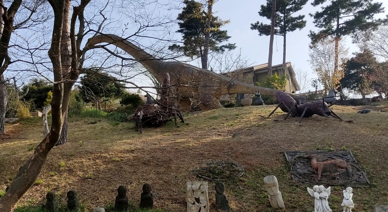 나무들과 공룡모형이 조화롭게 어우러진 조경공간