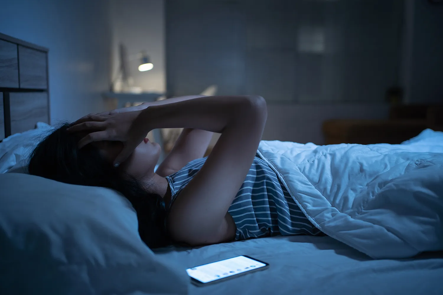 불면증으로 잠을 이루지 못하는 침대에 누워있는 여성