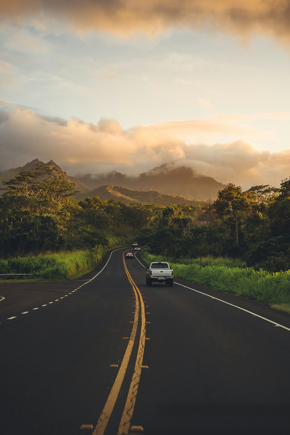 하와이의 높은 산과 포장된 도로 위에 다니는 차들