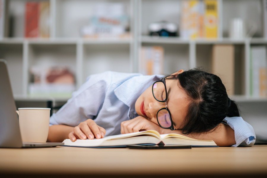 young-asian-tired-woman-eyeglasses-sleeping-desk-with-laptop-textbook-home