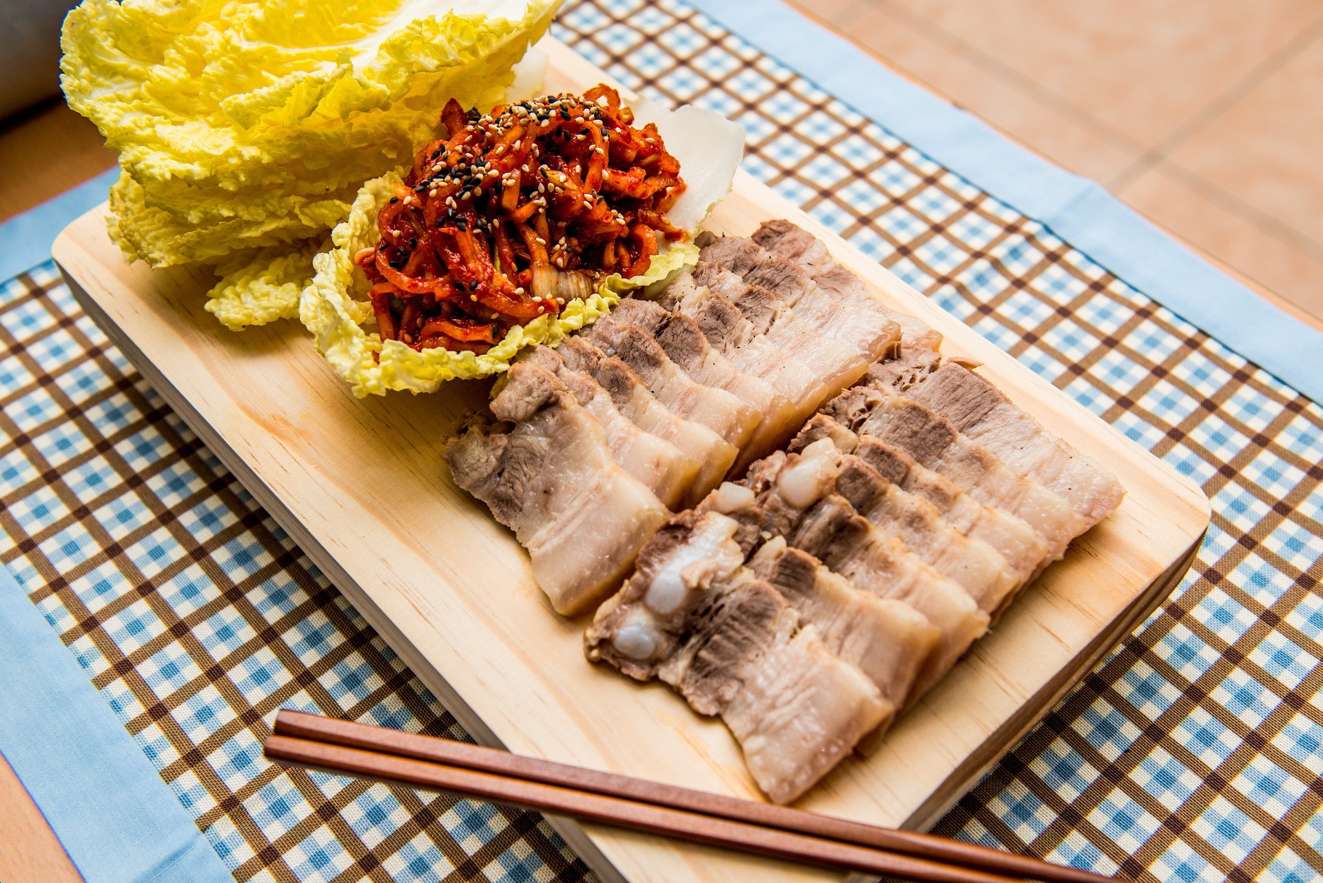 칼도마 위에 돼지고기를 삶아서 썰어 놓은 제육보쌈과 속배추&#44; 그리고 김치속 사진 - 소양인(少陽人)에게 맞는 음식