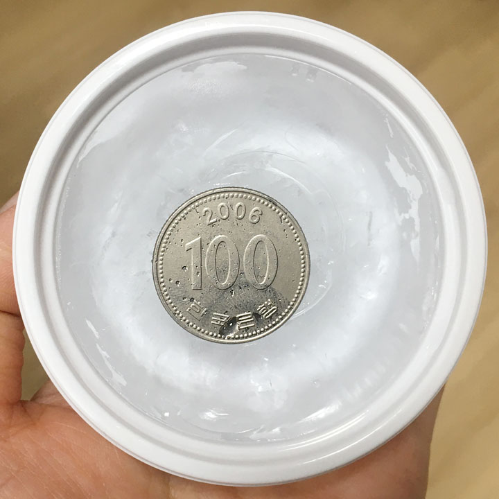 흰색-플라스틱-용기-얼음-위에-100원짜리-동전이-올려진-모습