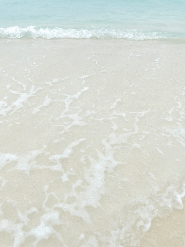 하얀 모래에 에메랄드 빛 바다와 파도 거품