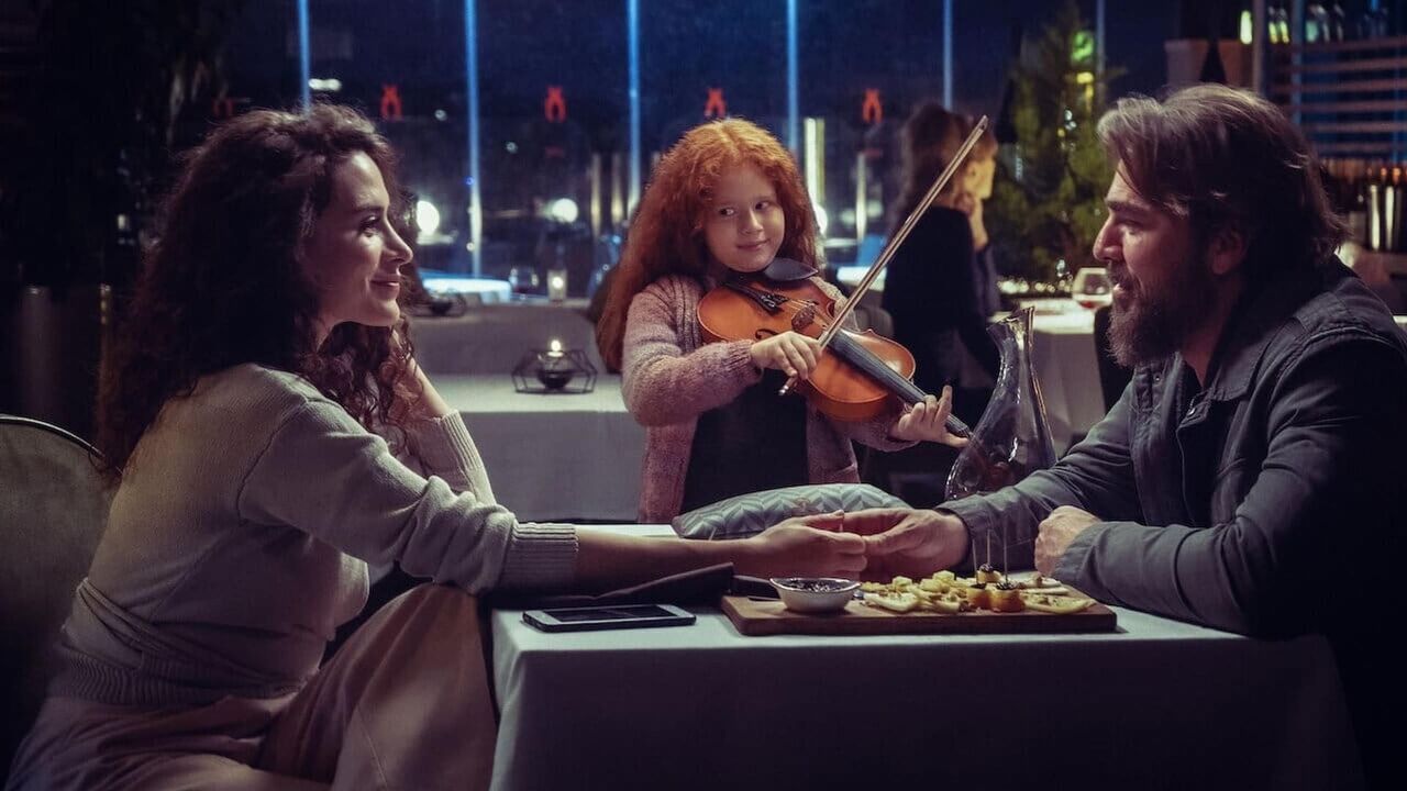 영화 &#39;아빠의 바이올린&#39; 중 식당에서 손을 잡고 있는 수나와 마히르 그리고 바이올린 연주를 하는 오즐렘의 모습이다.