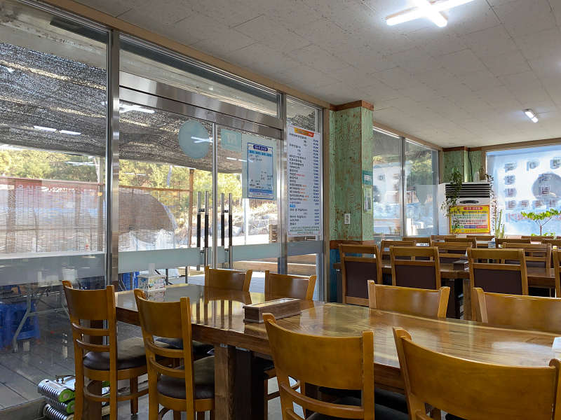 유리문 옆에 나무 테이블이 있습니다.