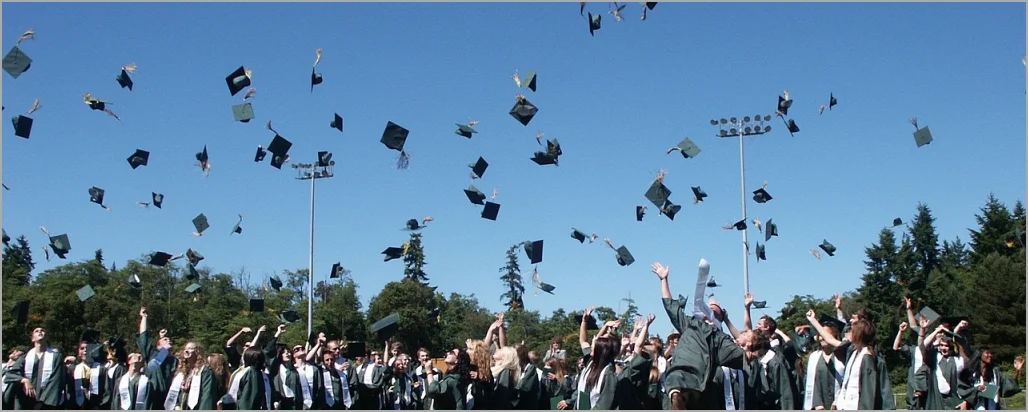대학교 졸업생들이 학사모를 하늘 높이 날리고 있다.