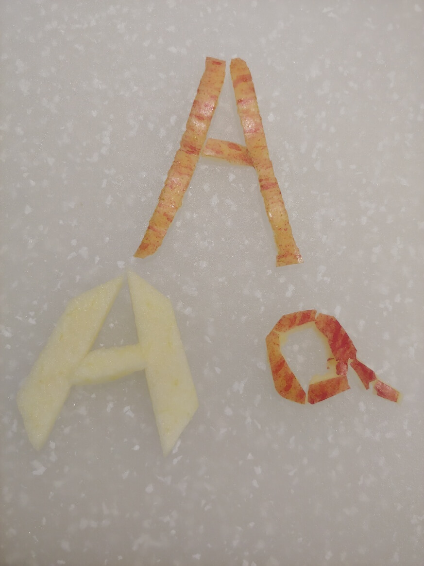 사과와 껍질로 알파벳 A를 만든 모습