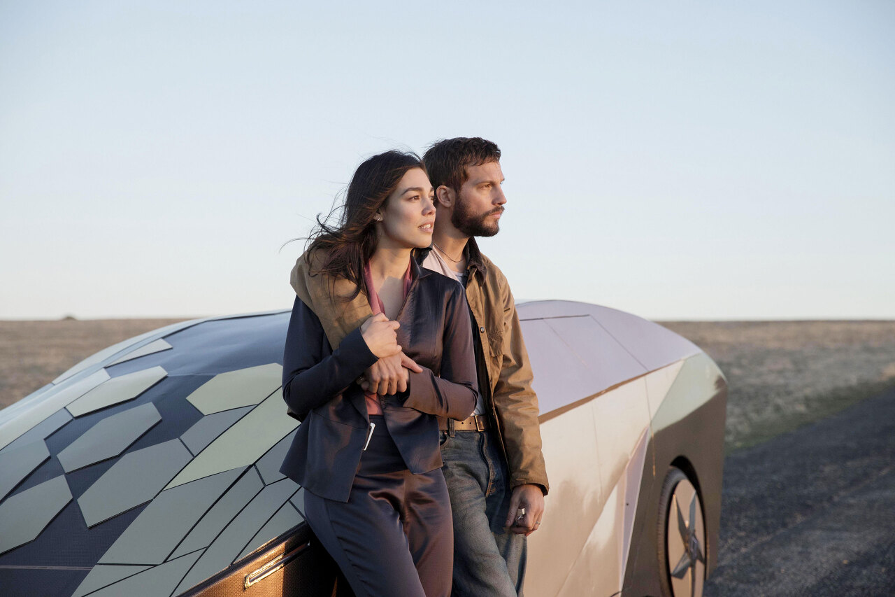 영화 &#39;업그레이드&#39;의 주인공 그레이와 그의 아내 아샤가 차에 기대고 풍경을 바라보는 모습이다.