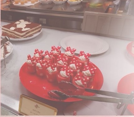 빨간 접시위에 크림 케이크가 올라가 있다.