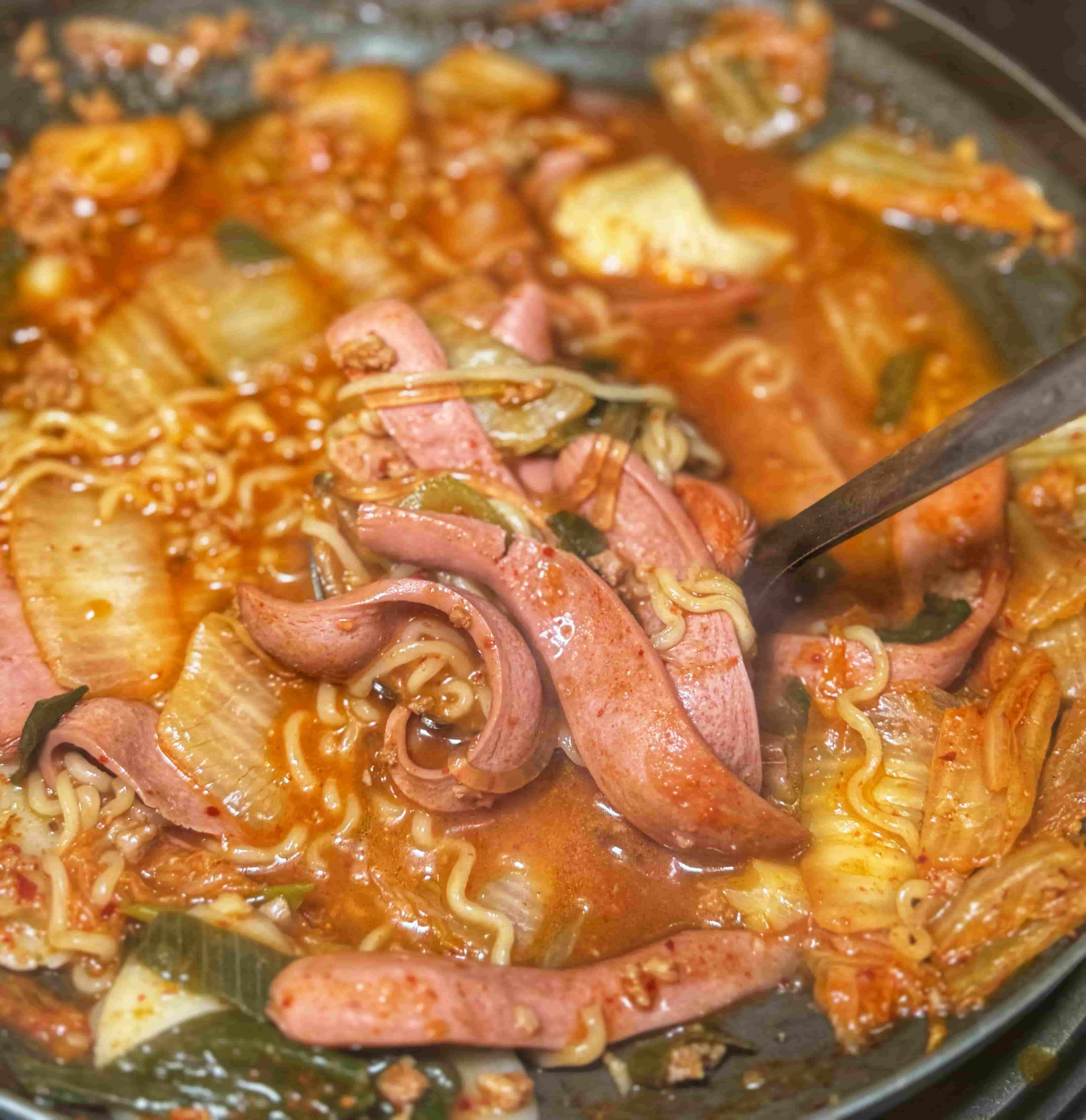 부대찌개의 햄과 소세지를 국자로 퍼 담은 사진