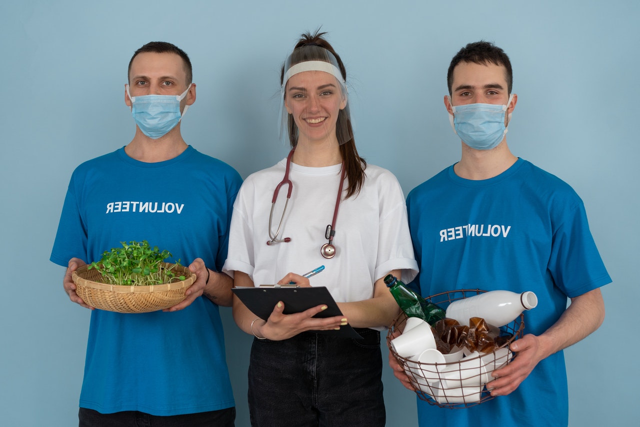 하얀색 옷을 입고 가운데 서 있는 여자와 파란색 옷을 입고 각각 식물과 플라스틱을 들고 마스크를 쓰고있는 남자 2명 