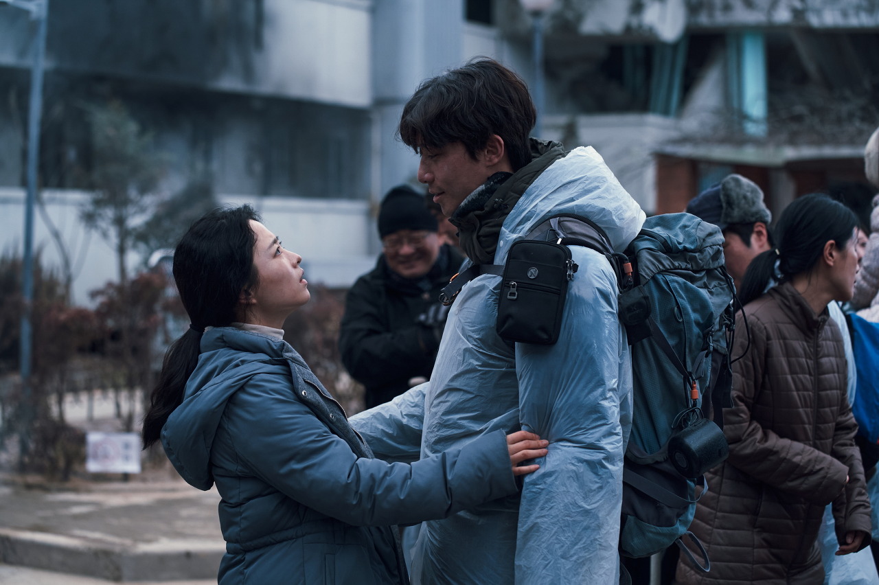 영화 콘크리트 유토피아에서 명화(박보영)와 민성(박서준)이 아파트 앞에서 마주 보는 장면이다.
