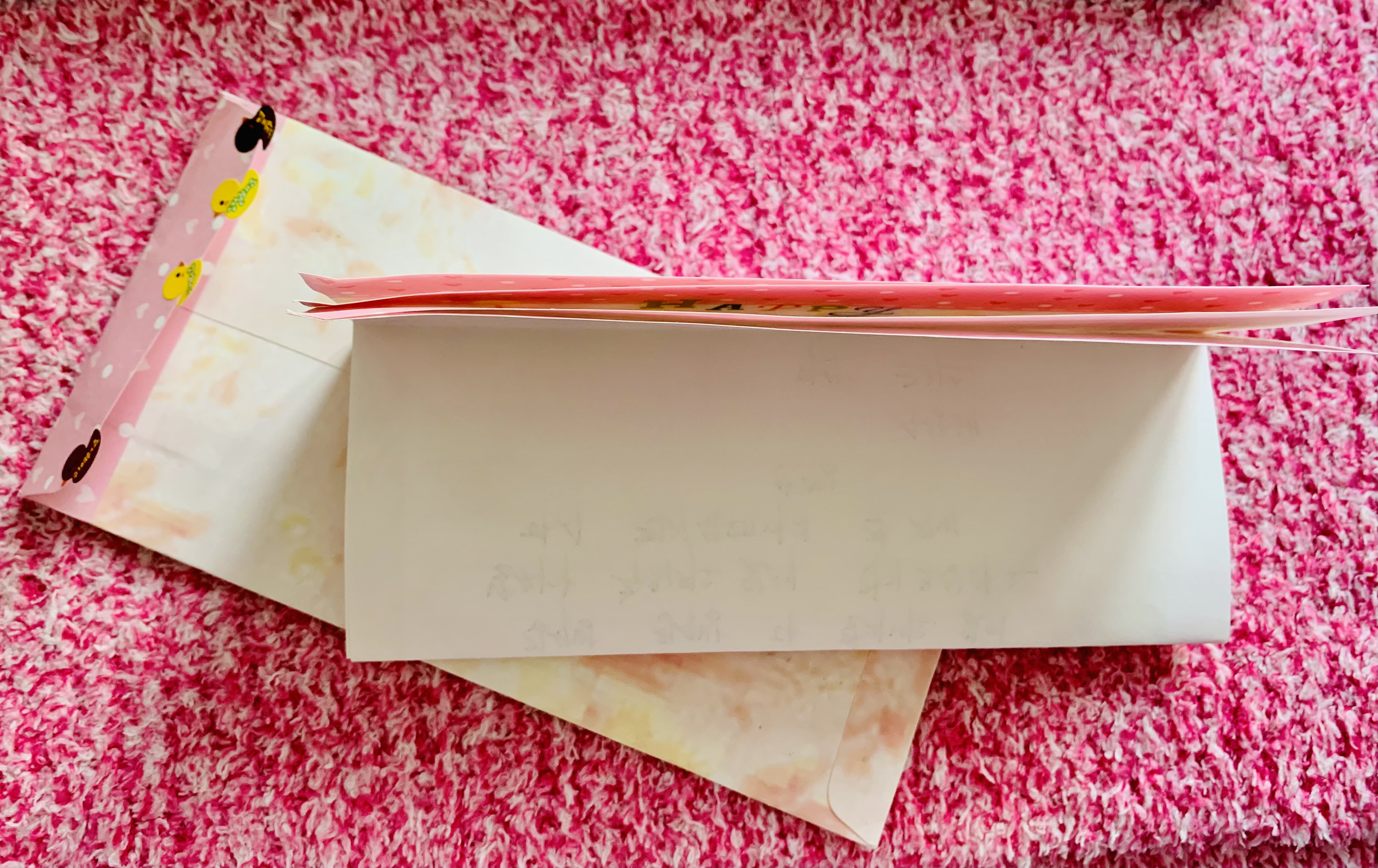 분홍색-매트위에-편지지와-편지봉투가-보이는-모습