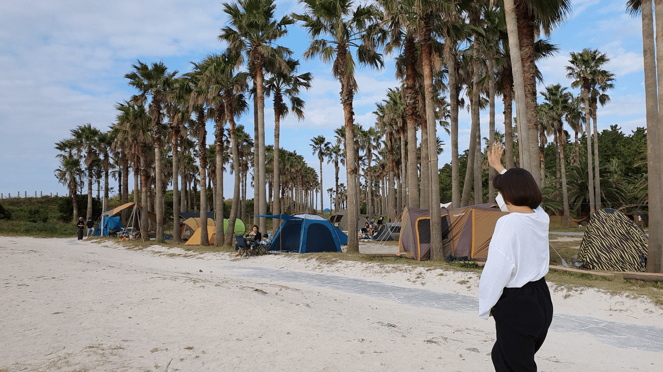 해변 야자수길에 즐비한 텐트와 여자
