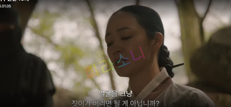 단정히 묶은 머리와 한복을 입은 송씨부인이 고개를 숙이며 말을 하고 있습니다. 배경은 나무가 우거진 야외 공간으로 보이며&amp;#44; 자막은 &amp;quot;얼굴을 그냥 짓이겨 버리면 될 게 아닙니까?&amp;quot;