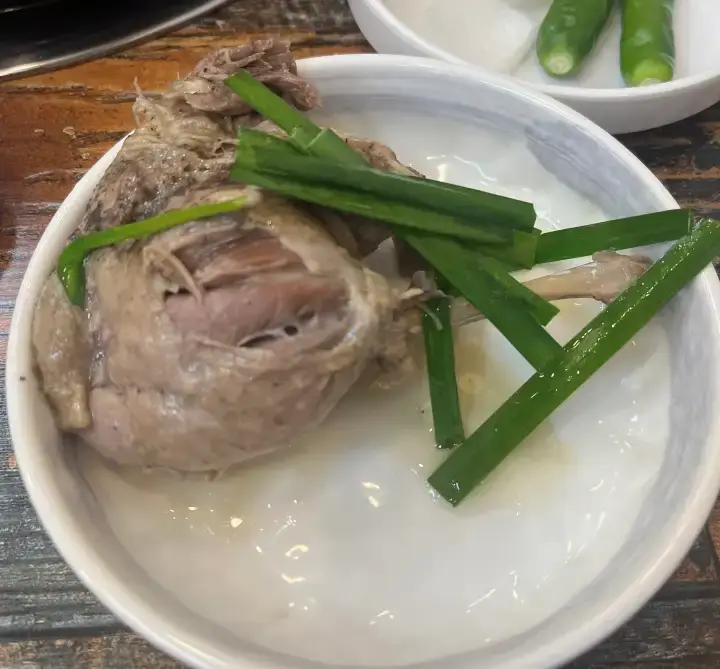 한방 능이 오리백숙 다리를 앞접시에 담은 사진