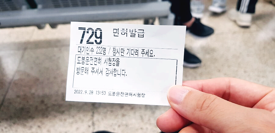 흰-종이에-검은-글씨가-써진-대기-번호표를-찍은-사진