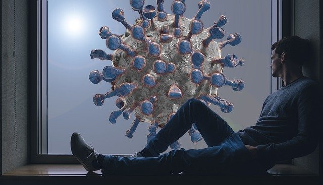 창밖에 있는 커다란 코로나 바이러스를 바라보고 있는 남성의 모습