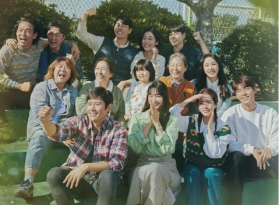 드라마 우리들의 블루스의 주요 등장인물들이 야외 계단에 앉아 밝게 웃으며 함께 사진찍는 모습