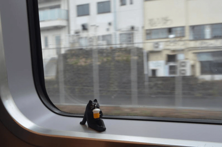 기차 창가에 놓여있는 맥주마시는 검은 고양이 피규어