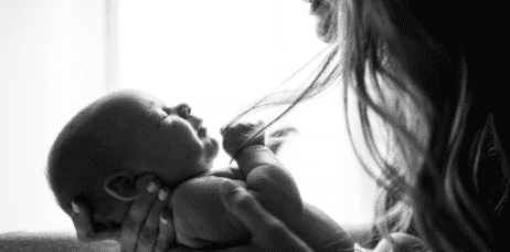 This image shows a new mom taking a nap while her baby is sleeping beside her&#44; which is a common situation for new moms who struggle with sleep deprivation. The warm and soft colors of the image create a calm and peaceful mood&#44; which is suitable for an article that discusses strategies for coping with sleep deprivation and exhaustion.