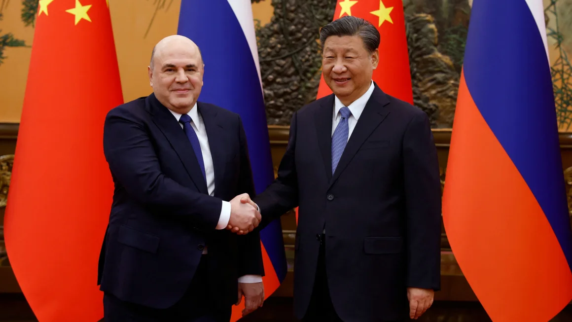 미하일 미슈스틴 러시아 총리와 시진핑 중국 국가주석이 베이징에서 회담에 앞서 악수하고 있다