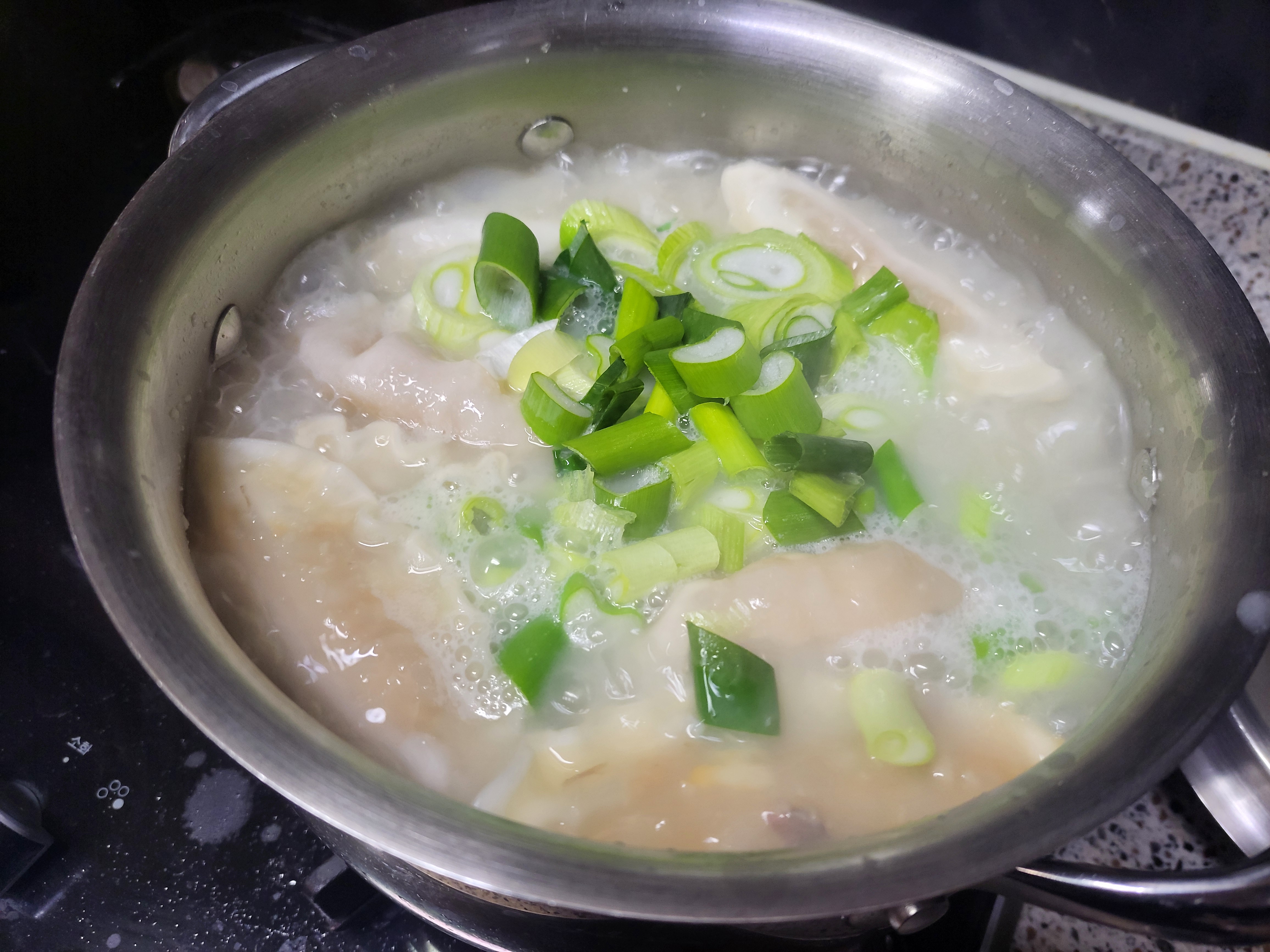 끓고있는 떡국에 파를 넣었다.