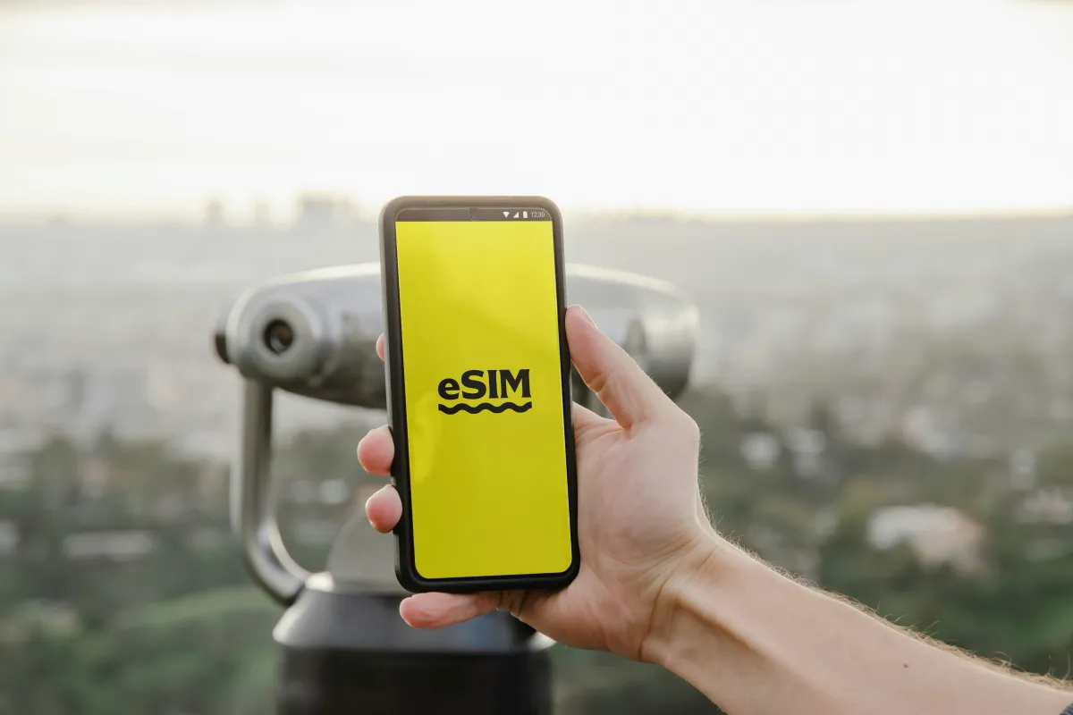 eSIM이라고-적혀있는-화면이-보이는-핸드폰을-들고있는-손
