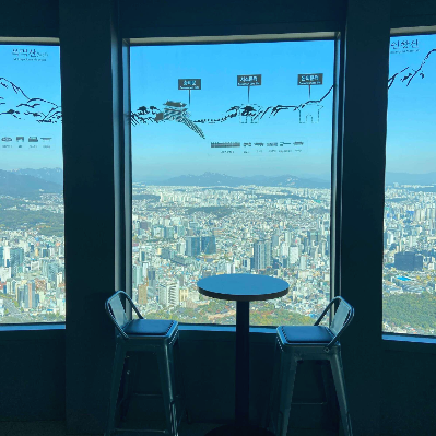 남산타워-전망대에서-창가에-테이블과-의자가-놓여있는-사진