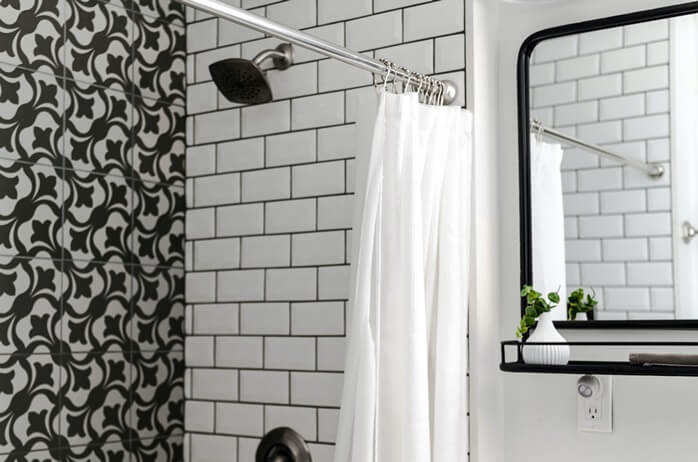 무채색의 북유럽풍 타일과 샤워 커튼과 샤워기가 있는 욕실