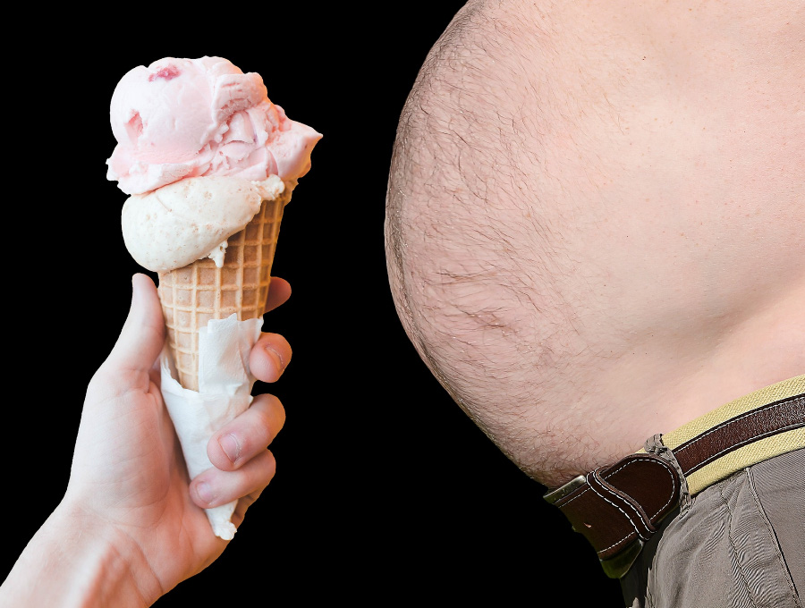 배가 많이 나온 사람의 배 앞에 핑크색 아이스크림 콘을 가져다 두고 비만의 원인임을 암시하는 사진