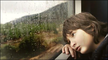 비오는 창 밖을 보고 있는 소년